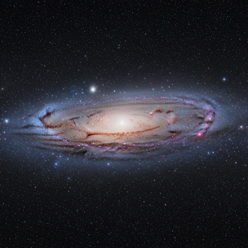 Fotografía astronómica de la galaxia de Andrómeda, mostrando su núcleo brillante y brazos espirales llenos de estrellas, polvo y nebulosas.